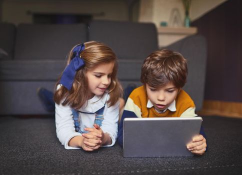 Learning for the future. adorable little kids using wireless technology at home