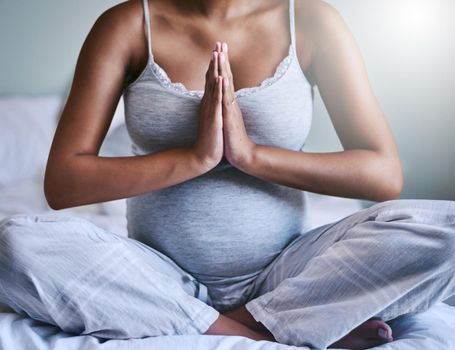 Yoga teaches you to stay calm. a pregnant woman doing yoga in her bedroom