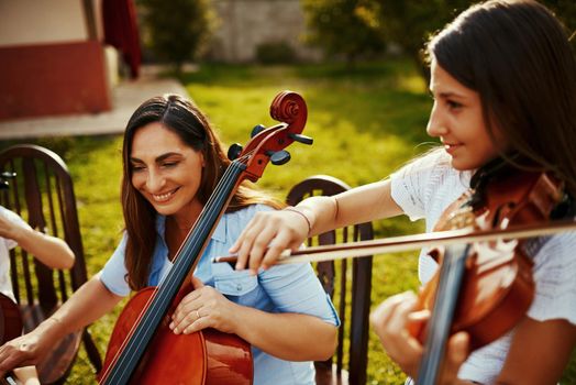 Playing music with her daughter brings her joy. a beautiful mother playing instruments with her adorable daughter outdoors