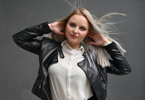 Beautiful woman with long hair posing in studio on grey background. Women Hair Is Fluttering In The Wind.