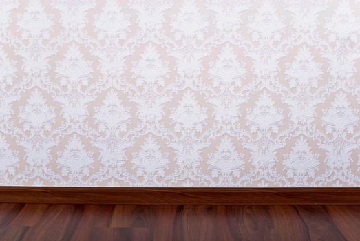 Wooden parquet floor and wallpaper on a wall close up