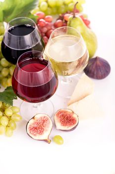 glasses of red and white wine and ripe grapes on table