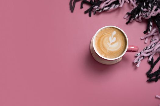 Autumn flat lay banner with cup of coffee latte and plaid on pink background. Creative autumn, thanksgiving, fall concept. Top view, copy space.