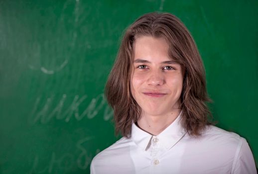 Schoolboy answering at blackboard in classroom.