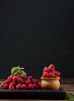 Ripe red raspberries on a brown wooden board