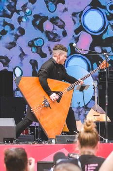 RUSSIA, SAMARA - JUNE 12, 2022: SamFest. Concert of the Balakir group at the stadium. A man plays the balalaika. Folk music.