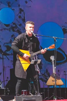 RUSSIA, SAMARA - JUNE 12, 2022: SamFest. Concert of the Balakir group at the stadium. A man plays the balalaika. Folk music.