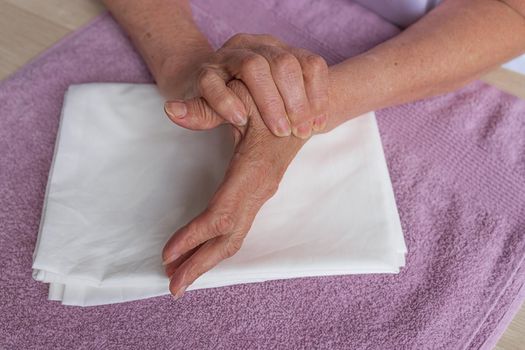 Self-massage of the hands of a caucasian old woman. Health of the fingers and joints of the hands. Self-massage. Healthy hand massage. Close-up of a man massaging his hand for pain in healthy concept