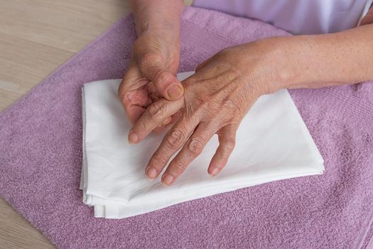 Self-massage of the hands of a caucasian old woman. Health of the fingers and joints of the hands. Self-massage. Healthy hand massage. Close-up of a man massaging his hand for pain in healthy concept