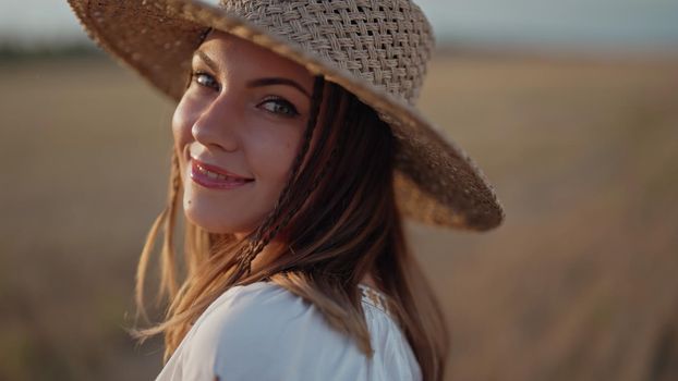 Portrait of ukrainian woman in wheat field after harvesting. Attractive cheerful lady in embroidery vyshyvanka blouse and straw hat. Ukraine, independence, freedom, patriot symbol, charming girl.