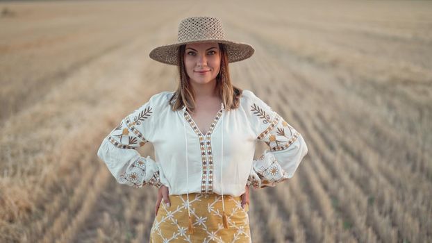 Portrait of ukrainian woman in wheat field after harvesting. Attractive cheerful lady in embroidery vyshyvanka blouse and straw hat. Ukraine, independence, freedom, patriot symbol, charming girl.