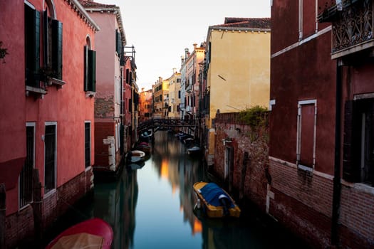 The architectural detail of an old bridge made with wooden on the typical canal in Venice