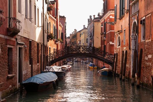 The architectural detail of an old bridge made with decorated iron on the typical canal in Venice