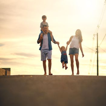 Walking through the neighbourhood as a family. a young family taking a walk down the road outside