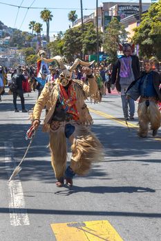 The group is performing a cultural dance with its roots in Spain representing the historic battle between the Moors and the Christians. The dance symbolizes taking the souls of the defeated Moors. The devils wear chaps (called chivarras) made of goat skin and hair, jacket and tie and a wooden mask.