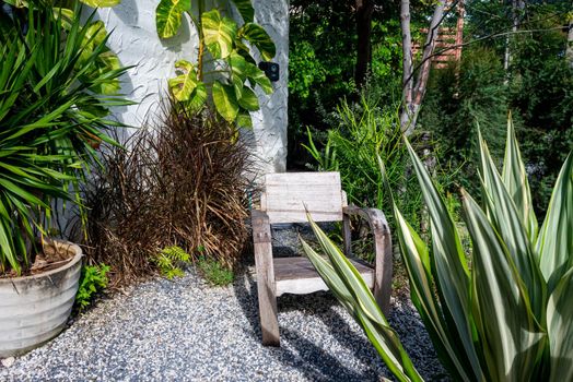 Scenic of timber armchair in the garden. Garden decoration with natural light.