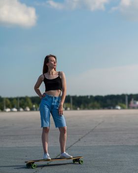 Young caucasian woman riding a longboard outdoors