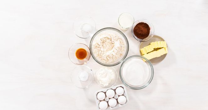 Flat lay. Ingredients in glass bowls to bake chocolate bundt cake with chocolate frosting.