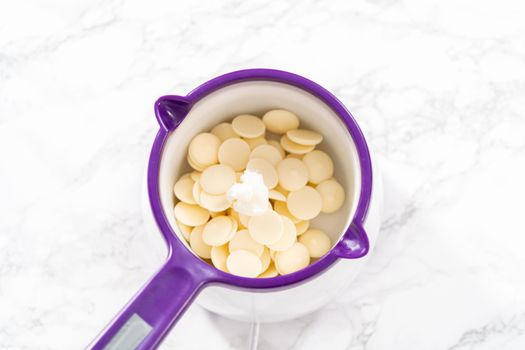 Melting chocolate melts in a candy melting pot to prepare mermaid tails and seashells chocolates.