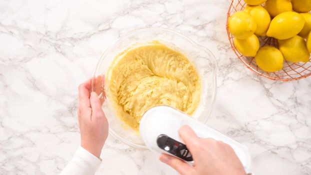 Flat lay. Step by step. Mixing ingredients in a glass mixing bowl to prepare lemon bundt cake.