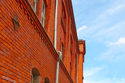 An old building made of red brick against a blue sky