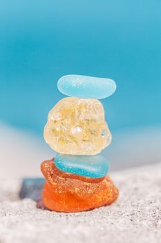 Macro shot of zen sea glass stone balance stack by the ocean. The act of balancing stones carries with it a practice of patience and a physical effort of creating balance and calm