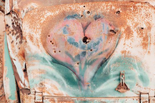 Heart in rusting metal with bullet holes. Concept abstract
