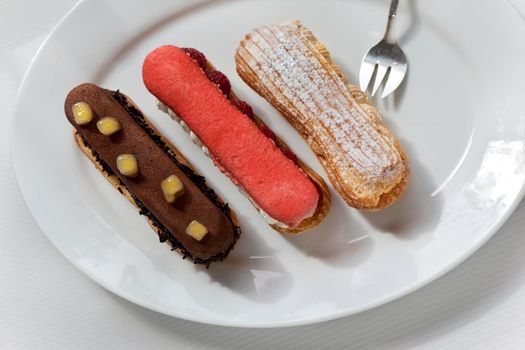 Three French Eclair cakes on a white plate