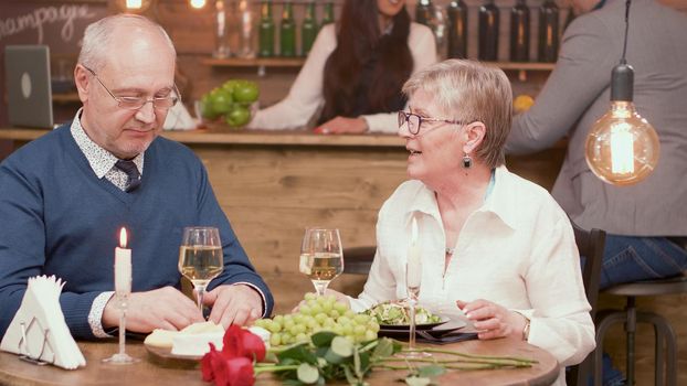 Two old friends in their sixties catching up on what they've been up to lately over dinner.