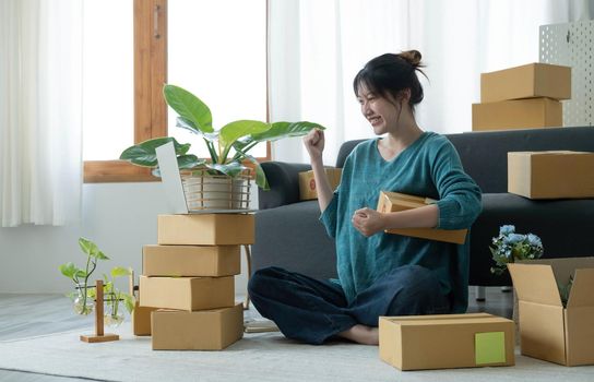 Portrait of Starting small businesses SME owners female entrepreneurs working on receipt box and check online orders to prepare to pack the boxes, sell to customers, SME business ideas online..