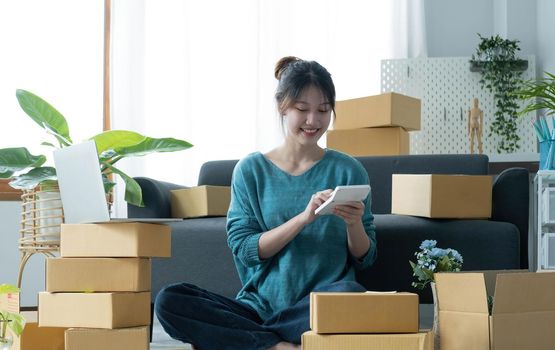 Business woman start up small business entrepreneur SME success .freelance woman working at home with Online Parcel delivery. SME and packaging deliveryconcept.