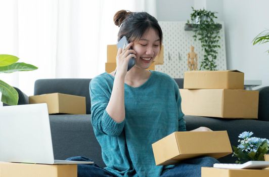 Startup small business entrepreneur SME, asian woman receive order on phone. Portrait young Asian small business owner home office, online sell marketing delivery, SME e-commerce telemarketing concept.