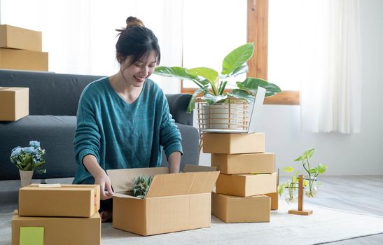 Young woman small business owner working at home office. Online marketing packaging delivery, startup SME entrepreneur or freelance woman concept. Small business owener.