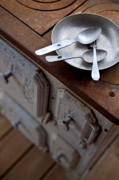 Cutlery and plate on an old rusty stove in a flea market