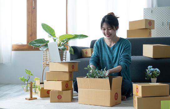 Young woman small business owner working at home office. Online marketing packaging delivery, startup SME entrepreneur or freelance woman concept. Small business owener.