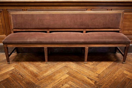 Velvet bench on a wooden floor inside a French palace