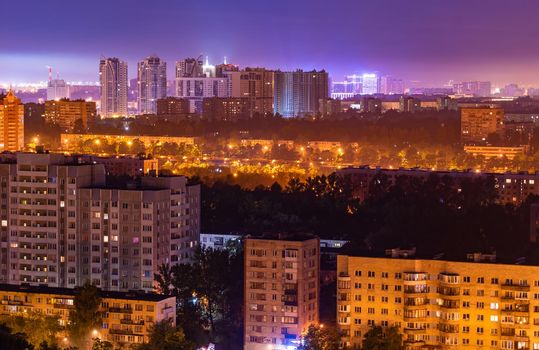 Night colorful windows lights of the high-rise residential building in city sleeping area