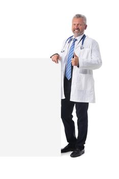 Full length portrait of a mature caucasian male doctor with blank banner isolated on white background