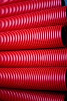 Close up of red plastic pipes on a construction site