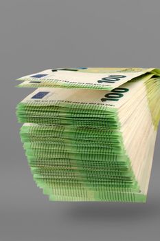 A large stack of 100 euro banknotes on a uniform gray background. Stack of banknotes as a concept of a loan, insurance payment, high income or mortgage.