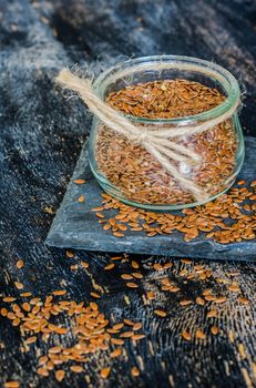 Organic food concept with flax seeds on dark wooden background