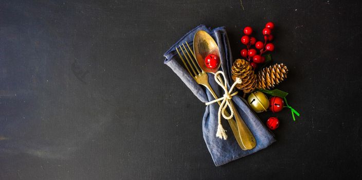 Table setting for Christmas dinner with festive decoration on dark wooden table with copyspace
