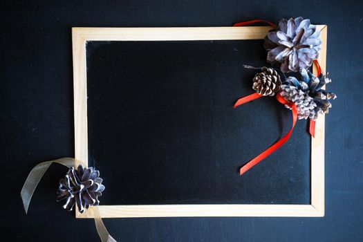 Christmas festive flatlay with cones on darkboard with copyspace