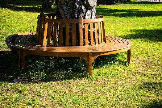Old styled wooden park bench in a city park