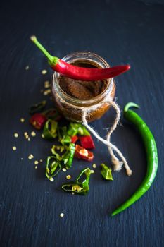 Traditional georgian sause ith hot chilli pepper - adjika, on dark wooden table