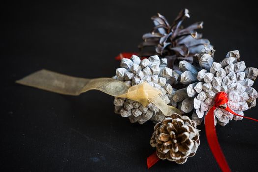 Christmas festive flatlay with cones on darkboard with copyspace