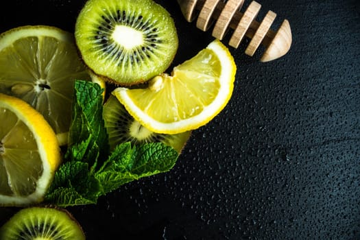 Flat lay with kiwi, lemon and mint on stone background with copyspace