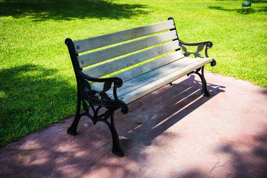 Old styled wooden park bench in a city park