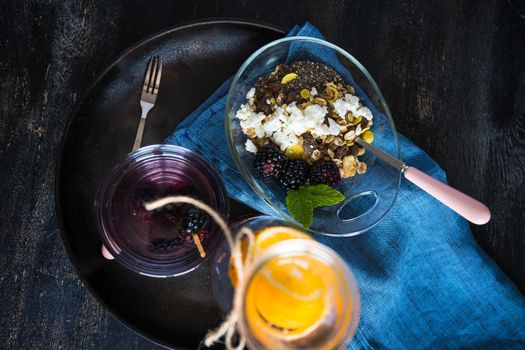 Oatmeal with chia and blackberries as a organic breakfast concept and detox drink of blackberries and lemon on dark rustic table