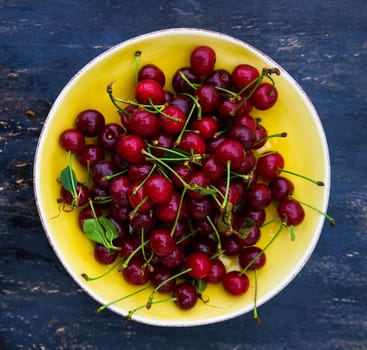 Fresh cherry berries on rustic wooden table and vintage background